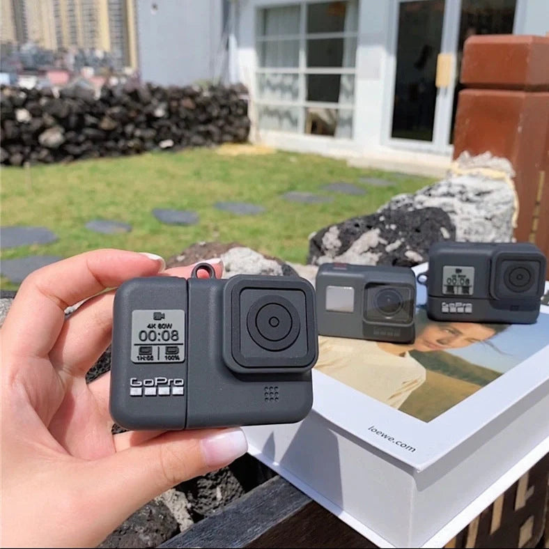Black silicone AirPods case with flip-top design and carabiner hook attachment