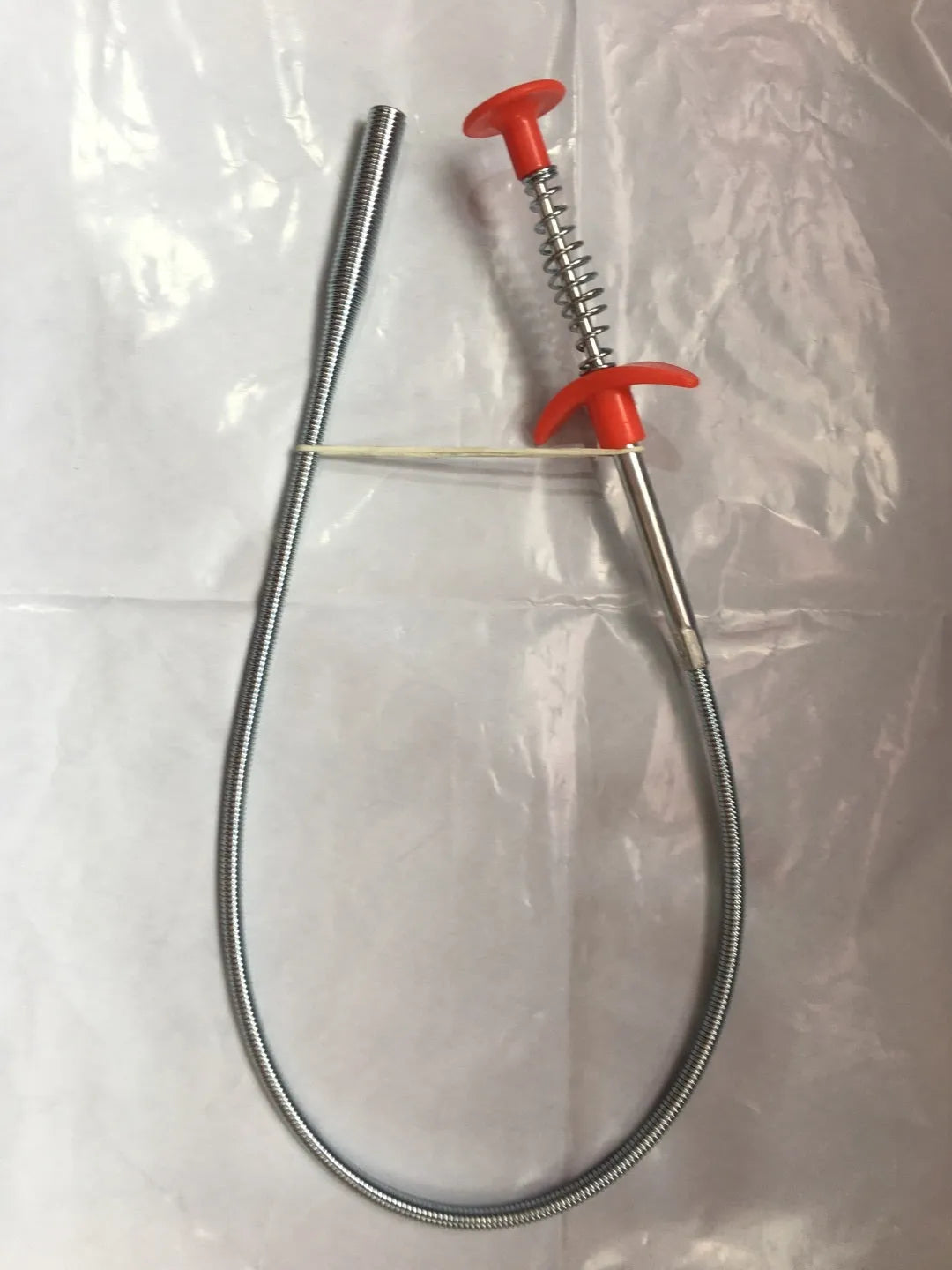 A black sewer dredge spring pipe cleaning tool for unblocking kitchen sink drains