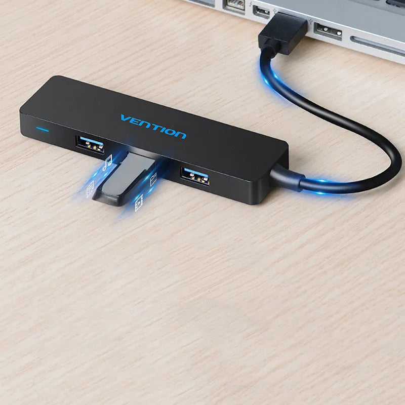 Black four-port USB 3.0 hub with a short cable on a white background.