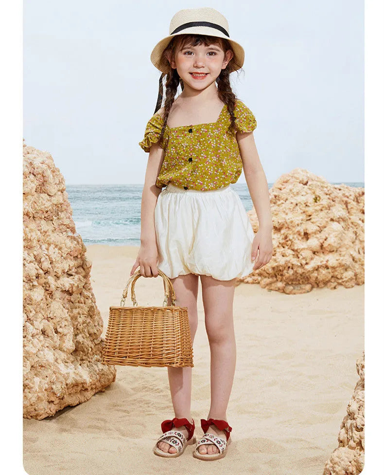 Red girls' soft-soled floral shoes with bow detail and Velcro strap, side view