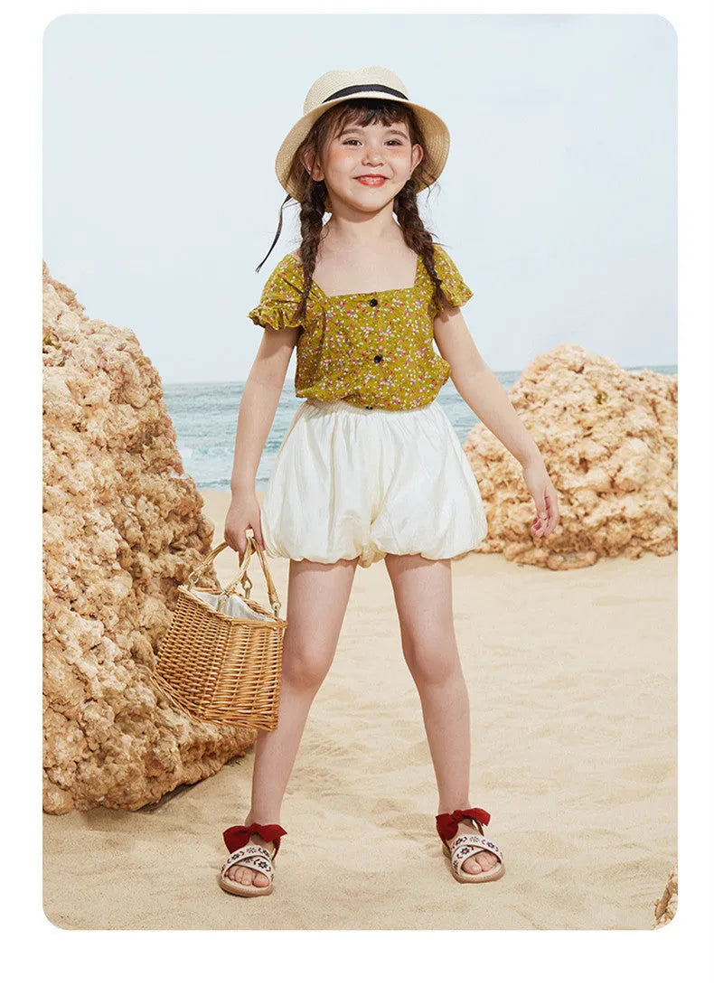 Red girls' soft-soled floral shoes with bow detail and Velcro strap, side view