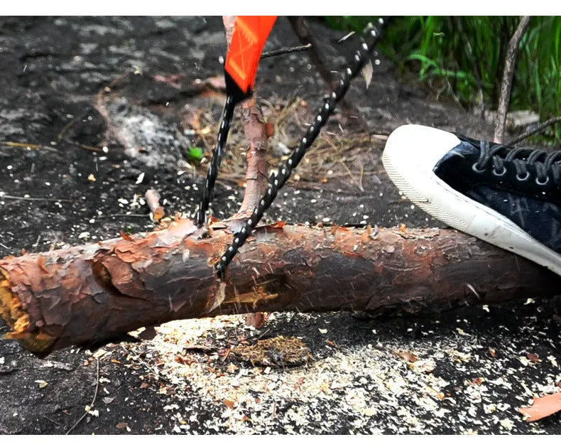 Manganese steel manual wire saw with black portable handle on natural ground