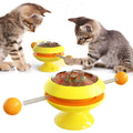 Rotatable cat toy with transparent top containing catnip balls and suction cup base