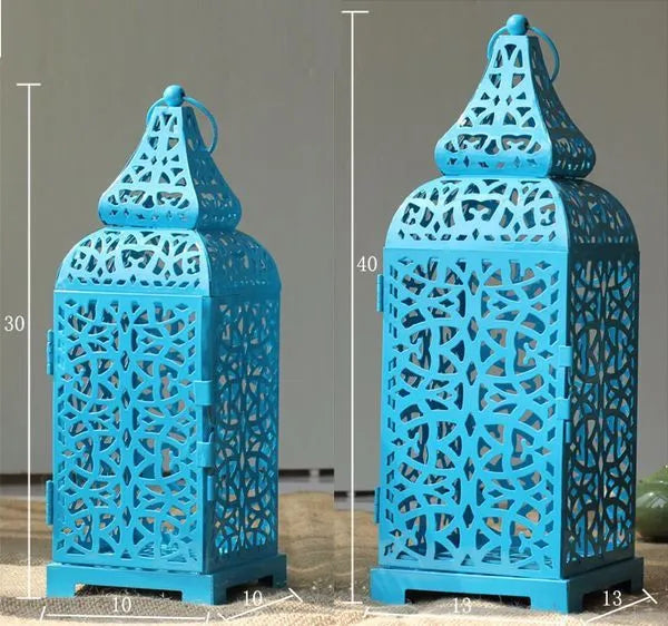 Blue retro hollow metal candelabra with geometric design on a wooden table.