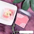 Pink self-adhesive plastic packaging bag for handmade soap with a gusseted side.