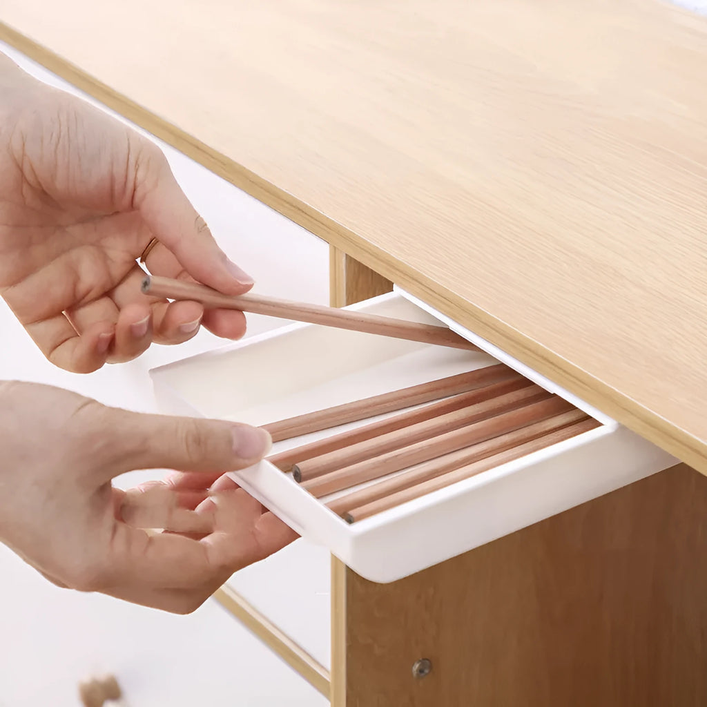 Grey Japanese-style plastic drawer storage box placed under a table for stationery organisation