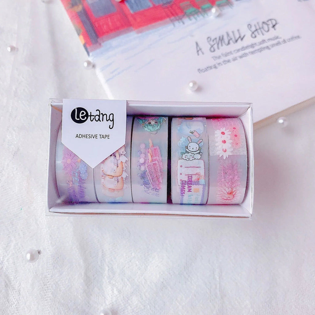 Five rolls of decorative washi tape showing dinosaur, duck, rabbit, and lucky cat designs for craft projects