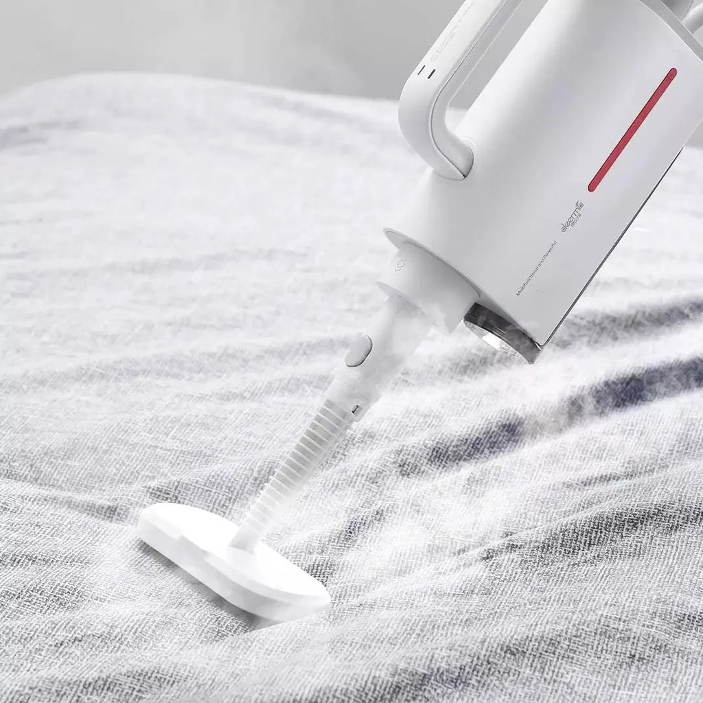 Deerma DEM-ZQ610 white steam cleaner main unit with brush heads, mop, and extension tubes on a floor.