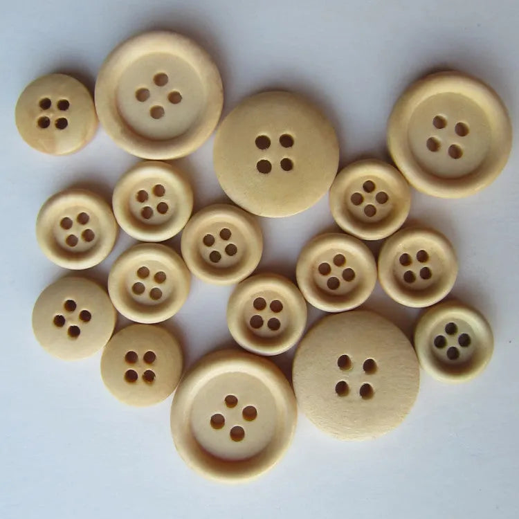 Round natural wood buttons in various sizes 10mm to 30mm on a white background concave flower design