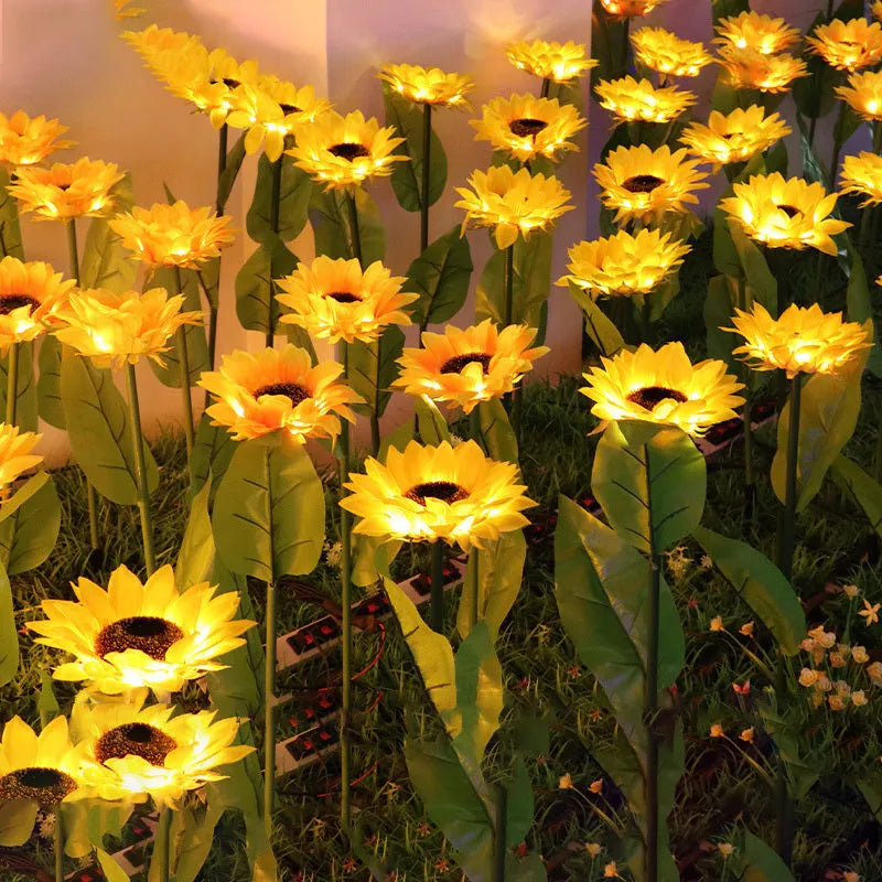 Yellow LED solar sunflower lamp on a lawn with a 66cm stem and 15cm flower head