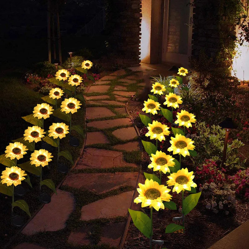 Yellow LED solar sunflower lamp on a lawn with a 66cm stem and 15cm flower head