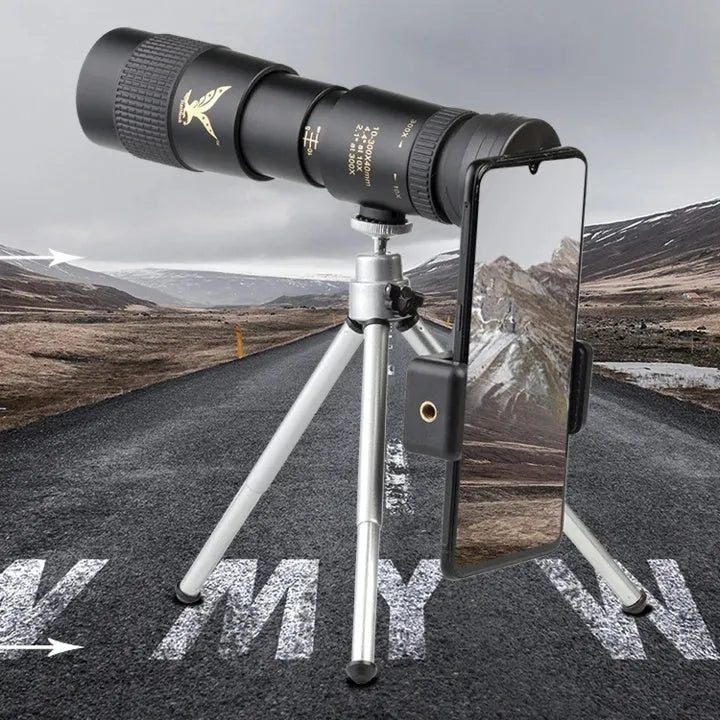 Black telescopic monocular 10-300x40mm with BAK4 prism and phone clip attached, on outdoor background