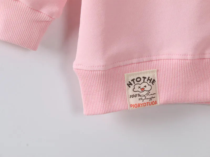 Baby girl wearing a soft, cartoon-print Korean-style sweatshirt for autumn.