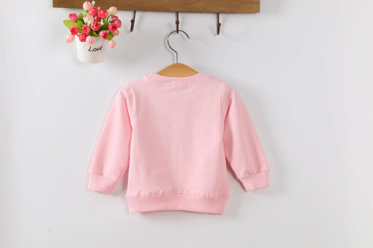 Baby girl wearing a soft, cartoon-print Korean-style sweatshirt for autumn.