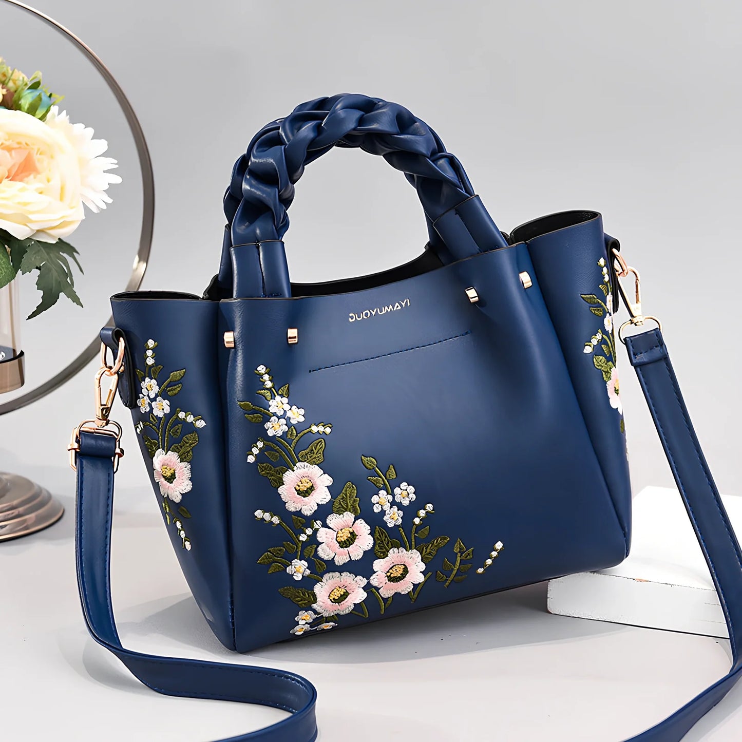 Women's medium tote bag with drawstring closure in PU leather, showing car stitching details