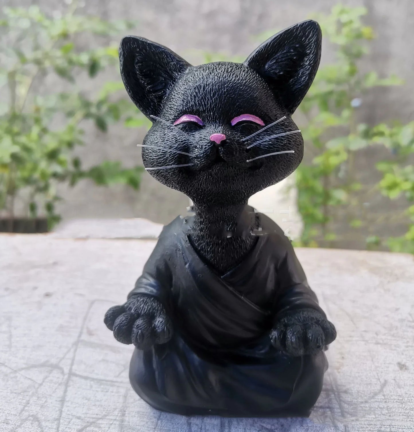 Charming ceramic Buddha cat figurine in black, grey, and orange colors for meditation, yoga, and home decor