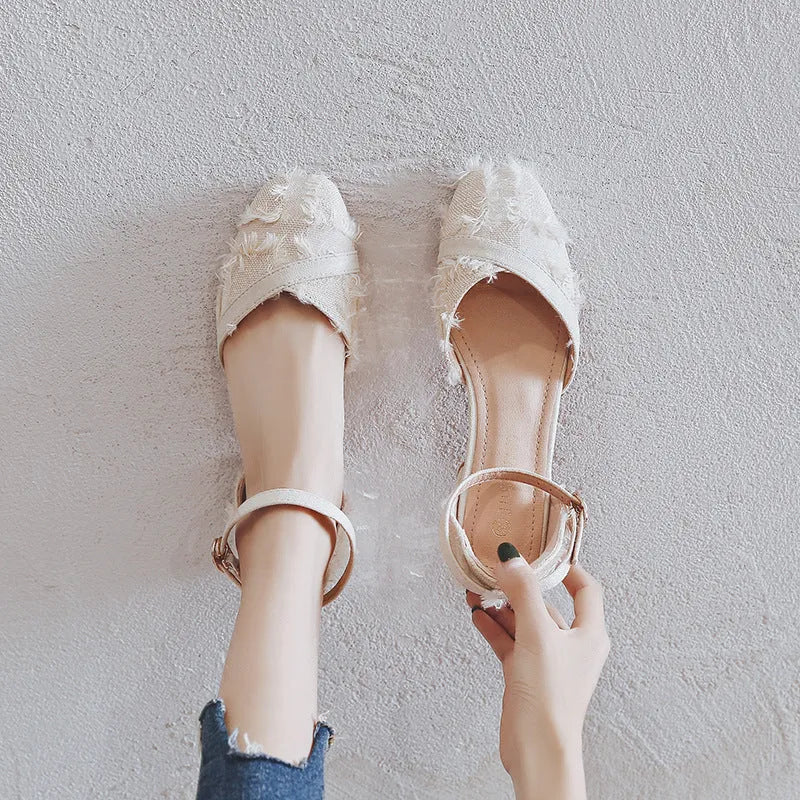 Women's apricot suede low-heel flats with an ankle strap in D'Orsay style on a white background.