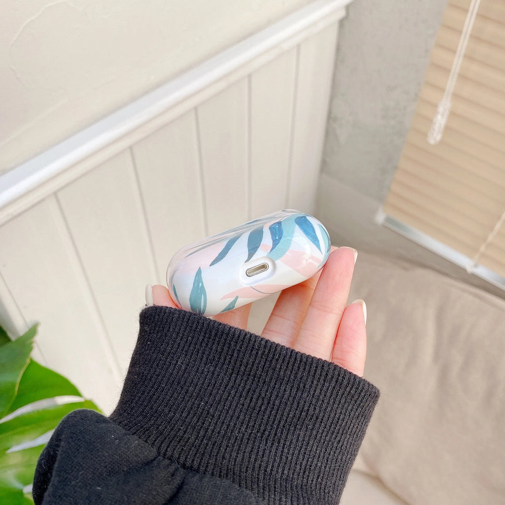 Blue and green TPU AirPods cases featuring a painted tropical banana leaf design.