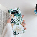 Green leaf flower patterned TPU phone case for Samsung Galaxy phones on a table.