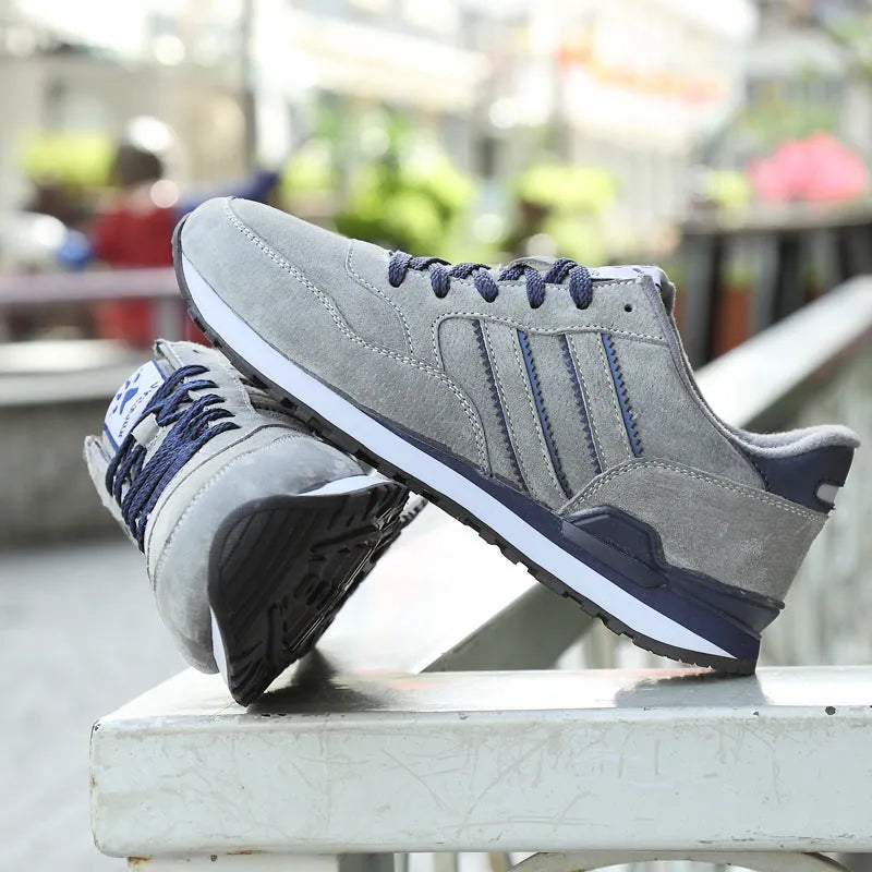 Men's blue pigskin leather sneakers with flat heel and rubber sole on grey background