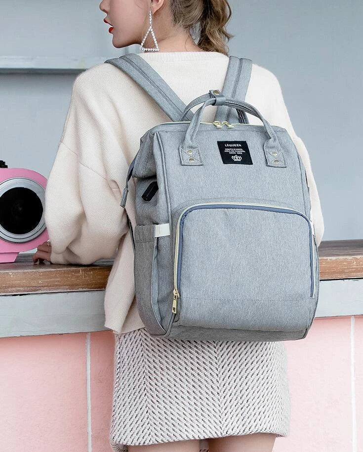 A stylish and practical mummy backpack with features like an insulated bottle compartment, USB charging port, and water-resistant construction.