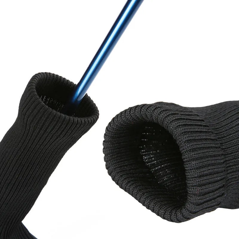 Set of six fabric golf club covers in blue, black, red, and multi-colour designs laid out on grass