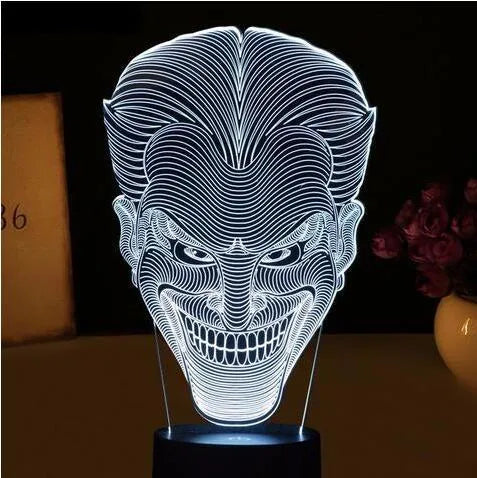 A 3D acrylic LED table lamp displaying colourful light patterns, with a remote control and USB cable.