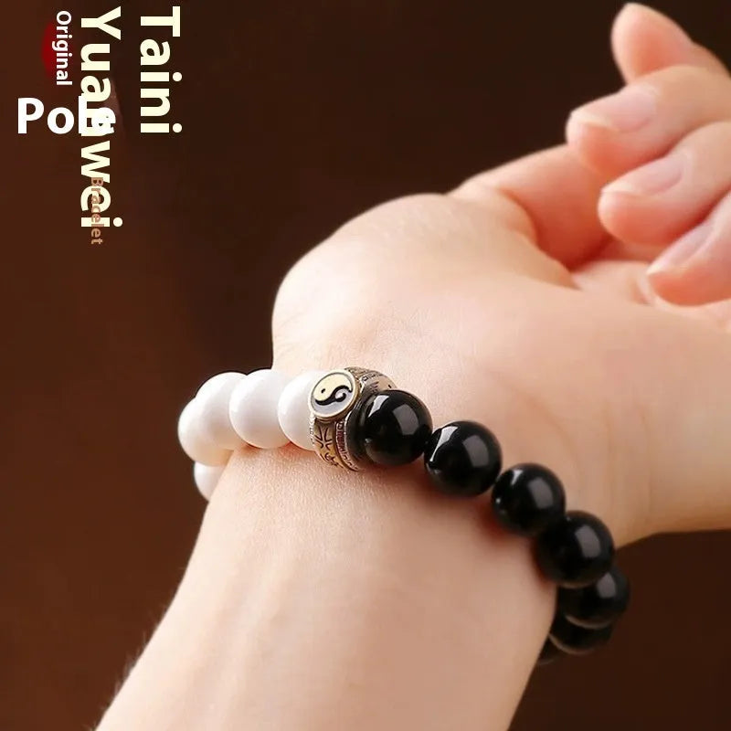 Black and white obsidian Taiji mantra bracelet with geometric beads and yin-yang symbol.