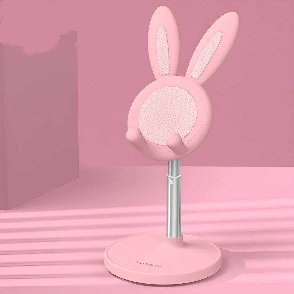 Rabbit-shaped silicone phone stand in pink on a desk with a smartphone placed in it