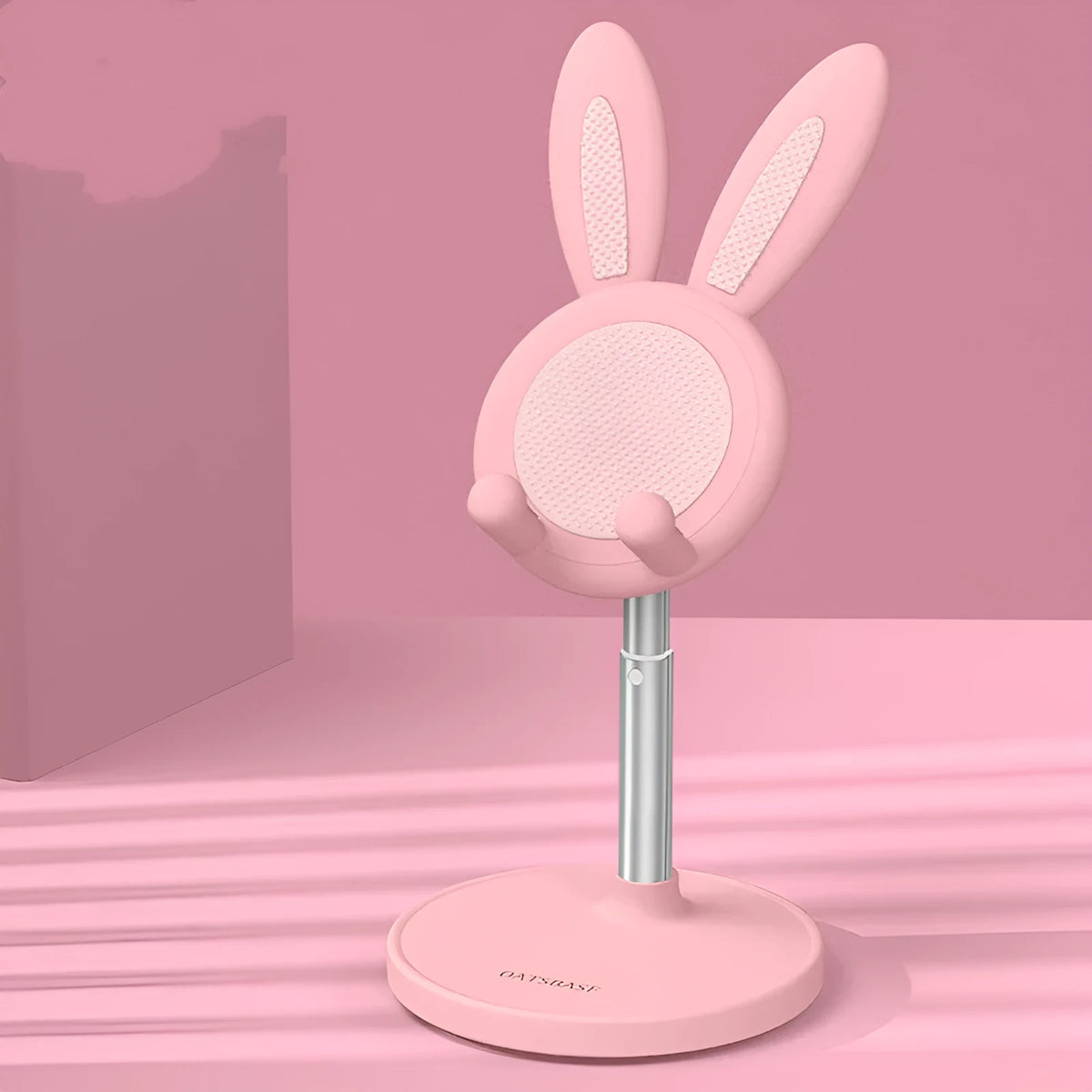 Rabbit-shaped silicone phone stand in pink on a desk with a smartphone placed in it
