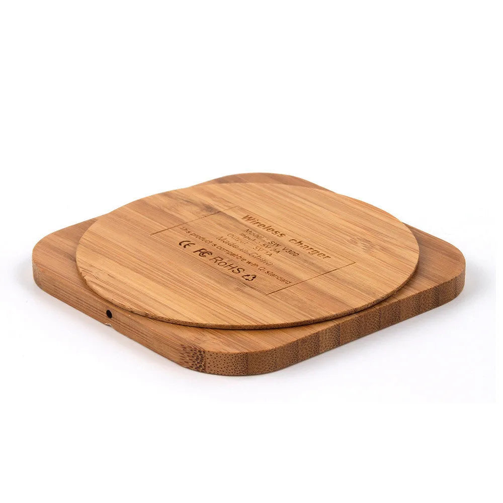 Square natural bamboo 5W QI wireless charging pad on a wooden surface.