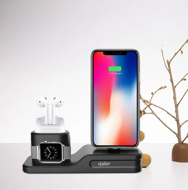 Black geometric 3-in-1 charging stand for Apple iPhone, Watch, and AirPods on a desk.
