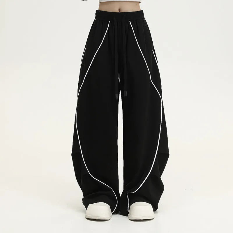 Black striped pleated wide-leg hip hop trousers on hanger showing mid-waist design