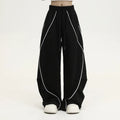 Black striped pleated wide-leg hip hop trousers on hanger showing mid-waist design