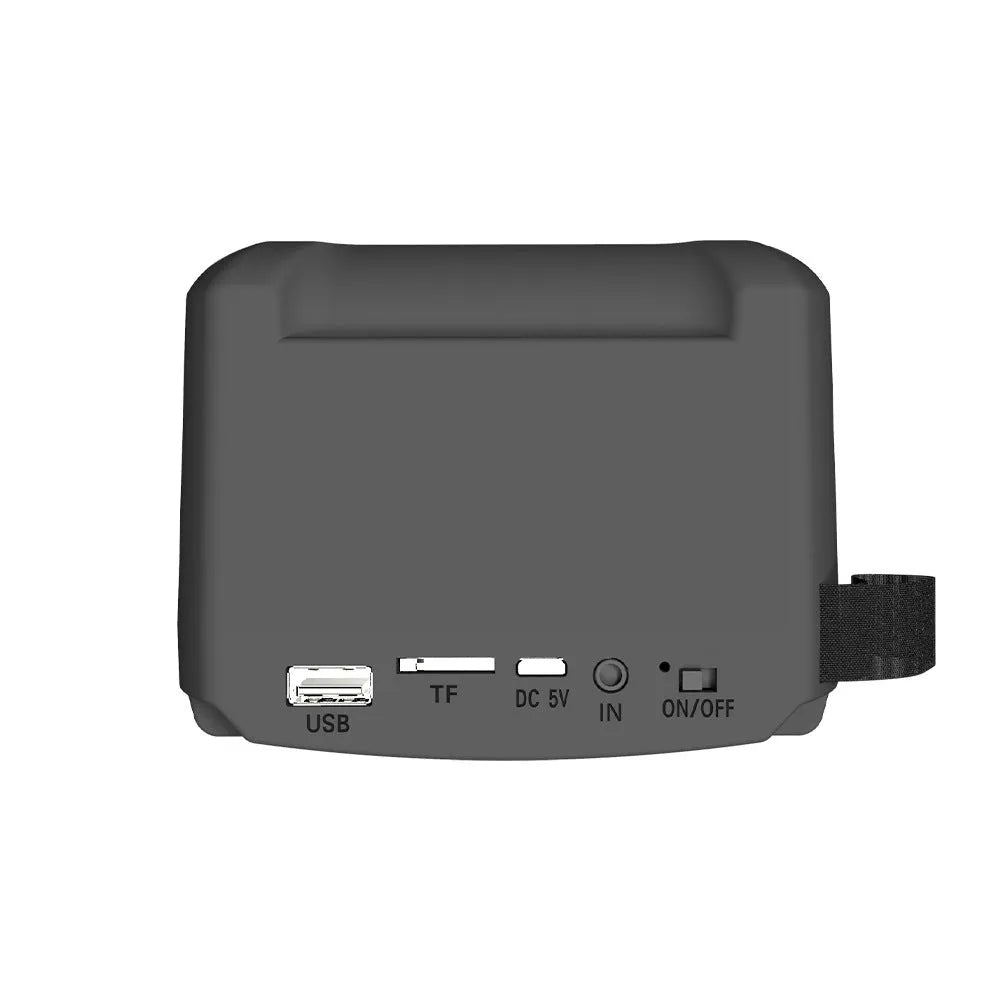 Compact portable Bluetooth speaker with USB charging cable on a desk.