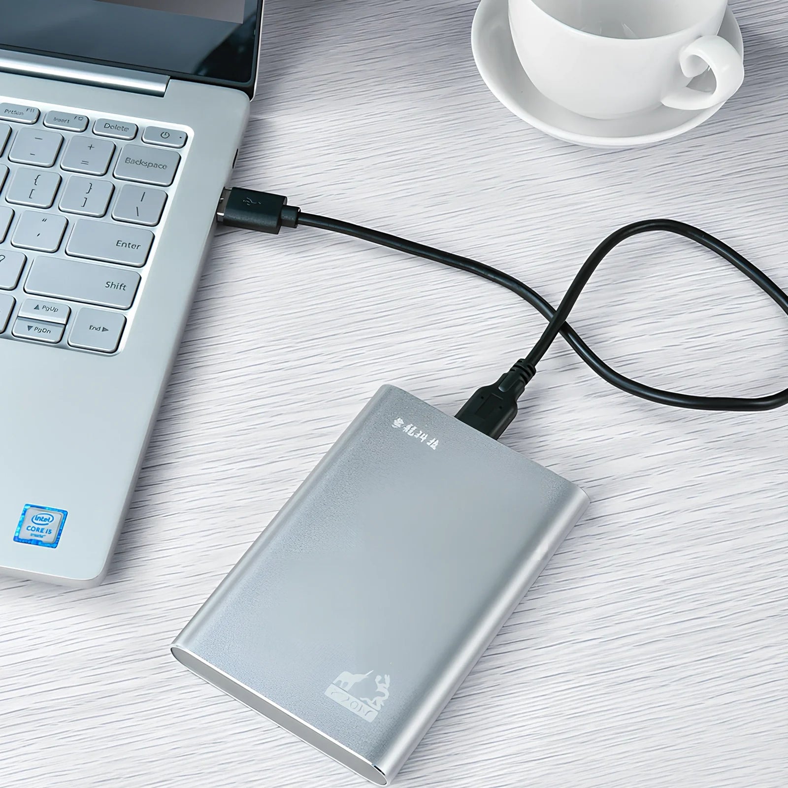 Black and silver 2.5-inch metal mobile hard drive with USB 3.0 connector showing activity light