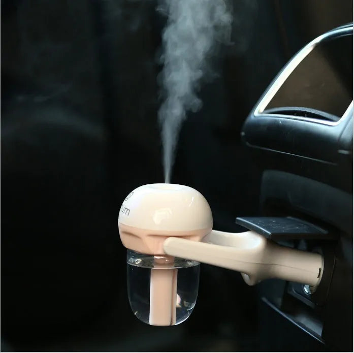 Compact portable car humidifier and air freshener unit with 180-degree rotating mist nozzle.