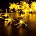 Outdoor solar-powered dragonfly LED string lights with garden spike-mounted panel