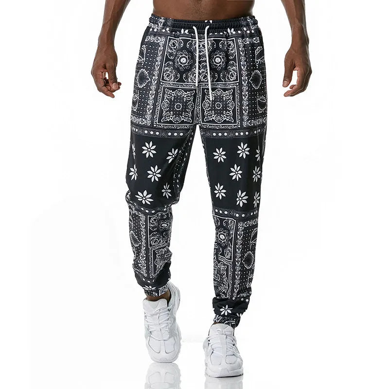 Printed jogging pants in loose fit with digital print pattern, mid waist, drawstring belt, and small-foot ribbed hem