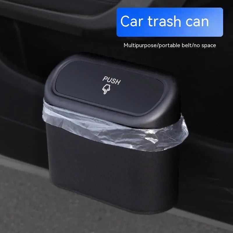 Black folding plastic car trash can shown in a vehicle footwell.