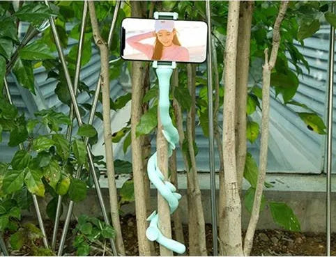 Black flexible arm phone holder with suction cup mounted on a desk, showing 360° rotation.