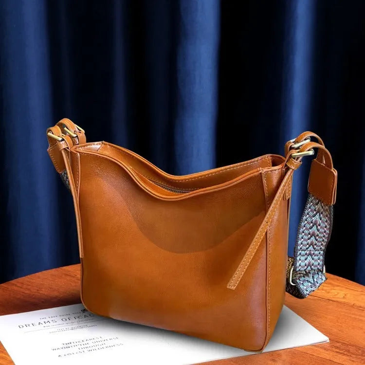 Women's black genuine leather messenger bag with multiple compartments and shoulder strap