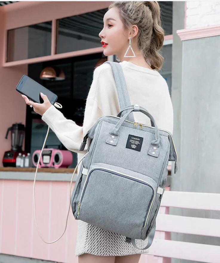 A stylish and practical mummy backpack with features like an insulated bottle compartment, USB charging port, and water-resistant construction.