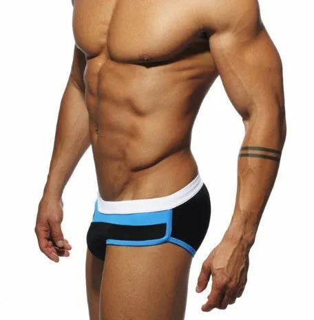 Men's nylon patchwork swim trunks in black with brief cut for swimming