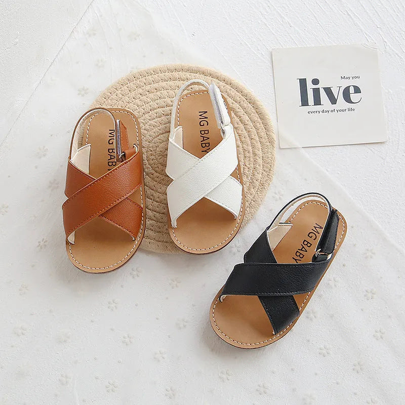 Children's cross strap Velcro sandals in brown, PU upper, beef tendon sole, side view on beach