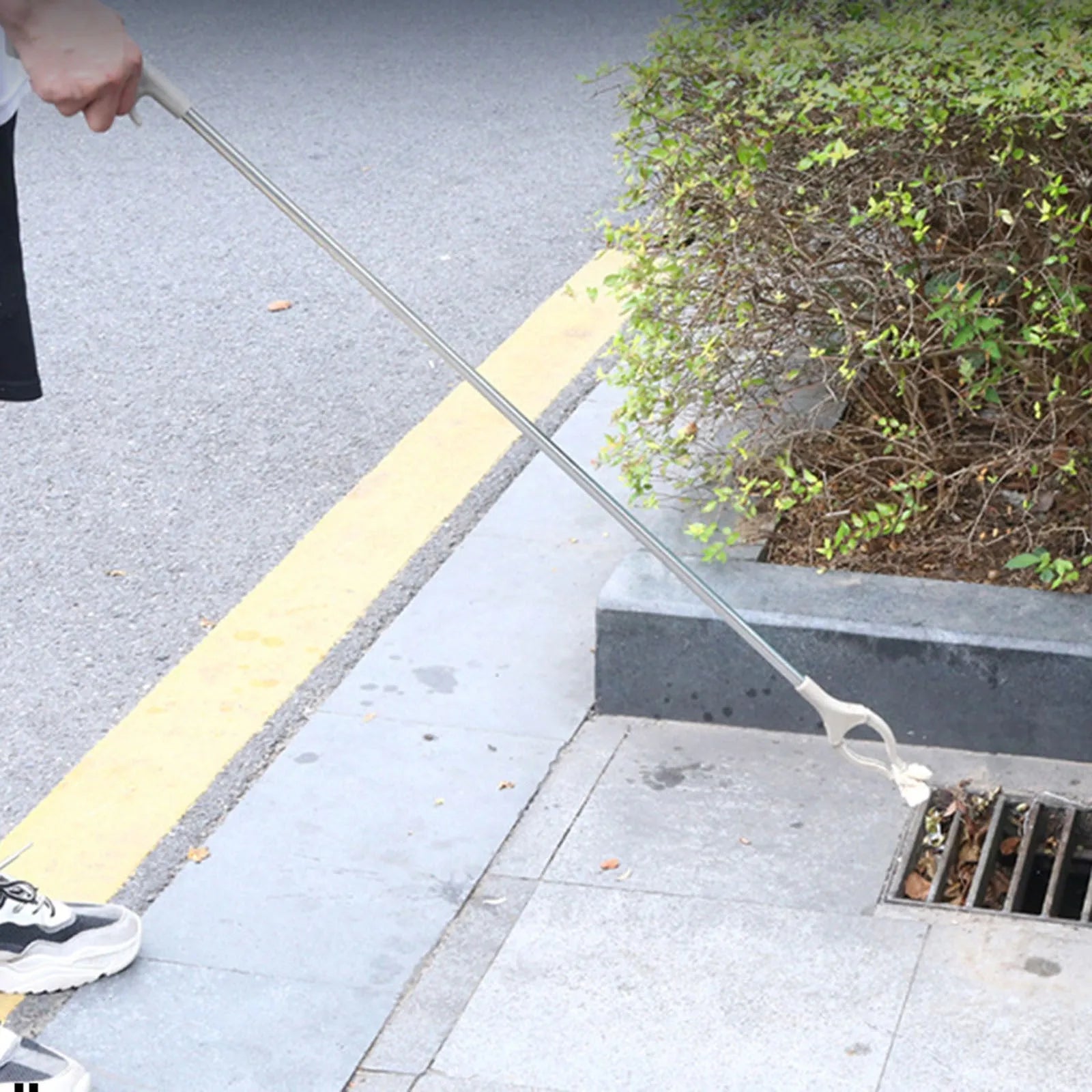 Stainless steel garbage picker with extended 40cm handle and non-slip gripper jaws.