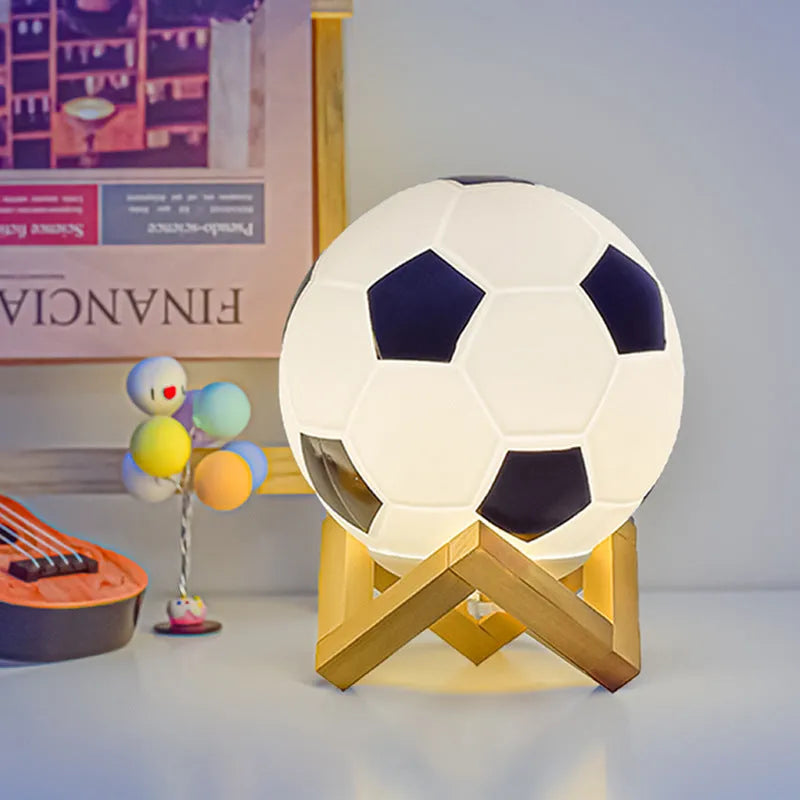 Football LED small night lamp with glass shade and remote control on a bedside table
