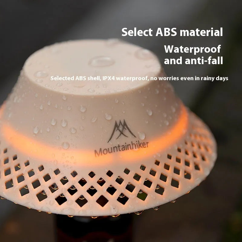 Beige wine bottle shaped camping lantern with USB-C port on a wooden table.