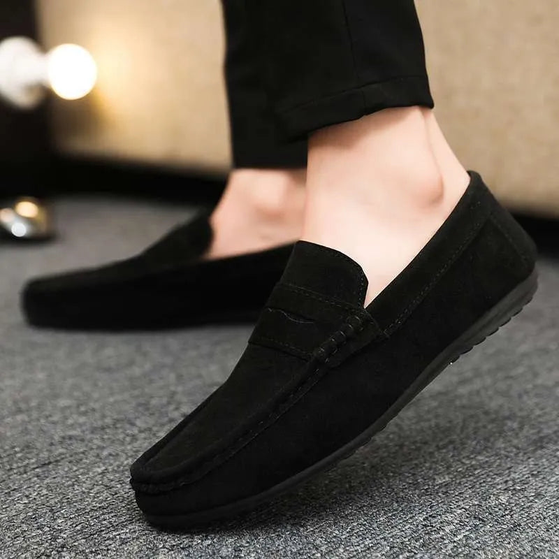 Men's black Gommino Korean fashion slip-on shoes with round toe and textured grape particle detailing on the PU upper.