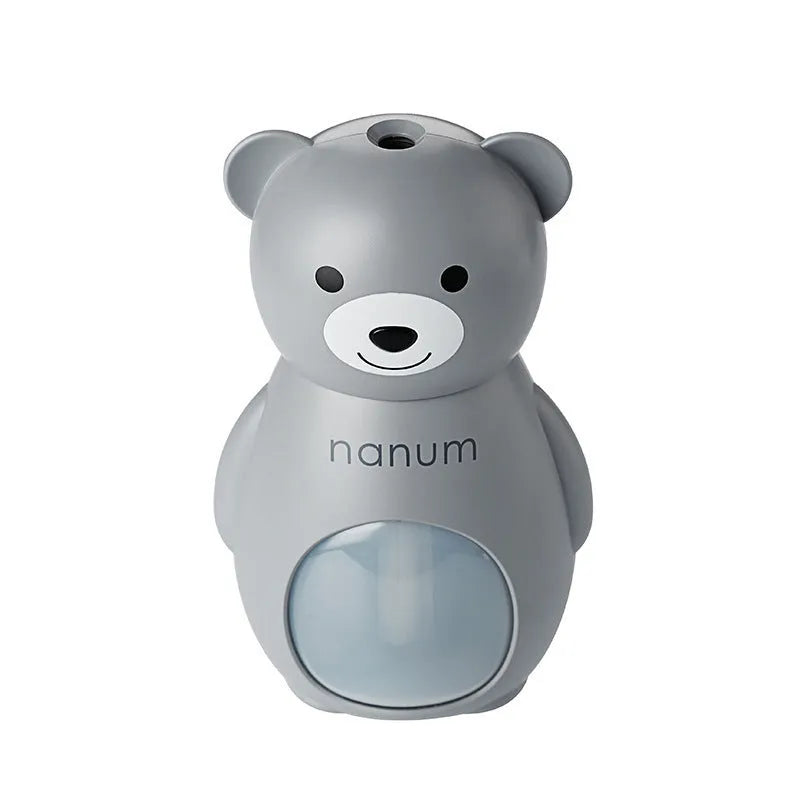 Animal-shaped USB mini humidifier in white plastic with single mist outlet and mechanical timer knob on a desk.
